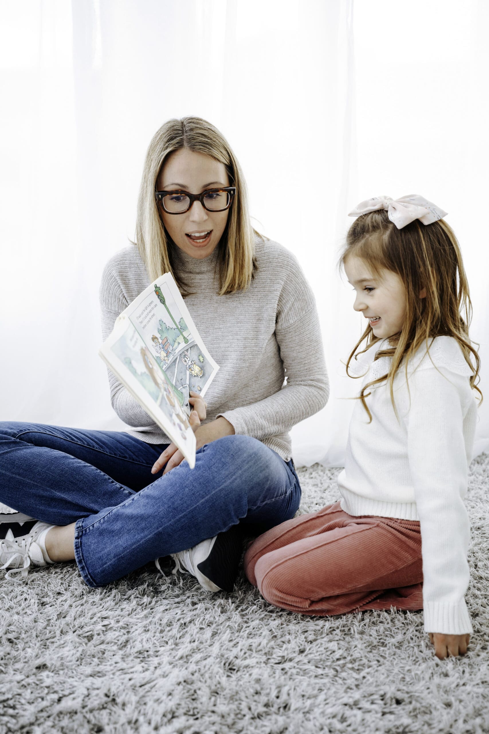 An SLP and a little girl looking at a book together