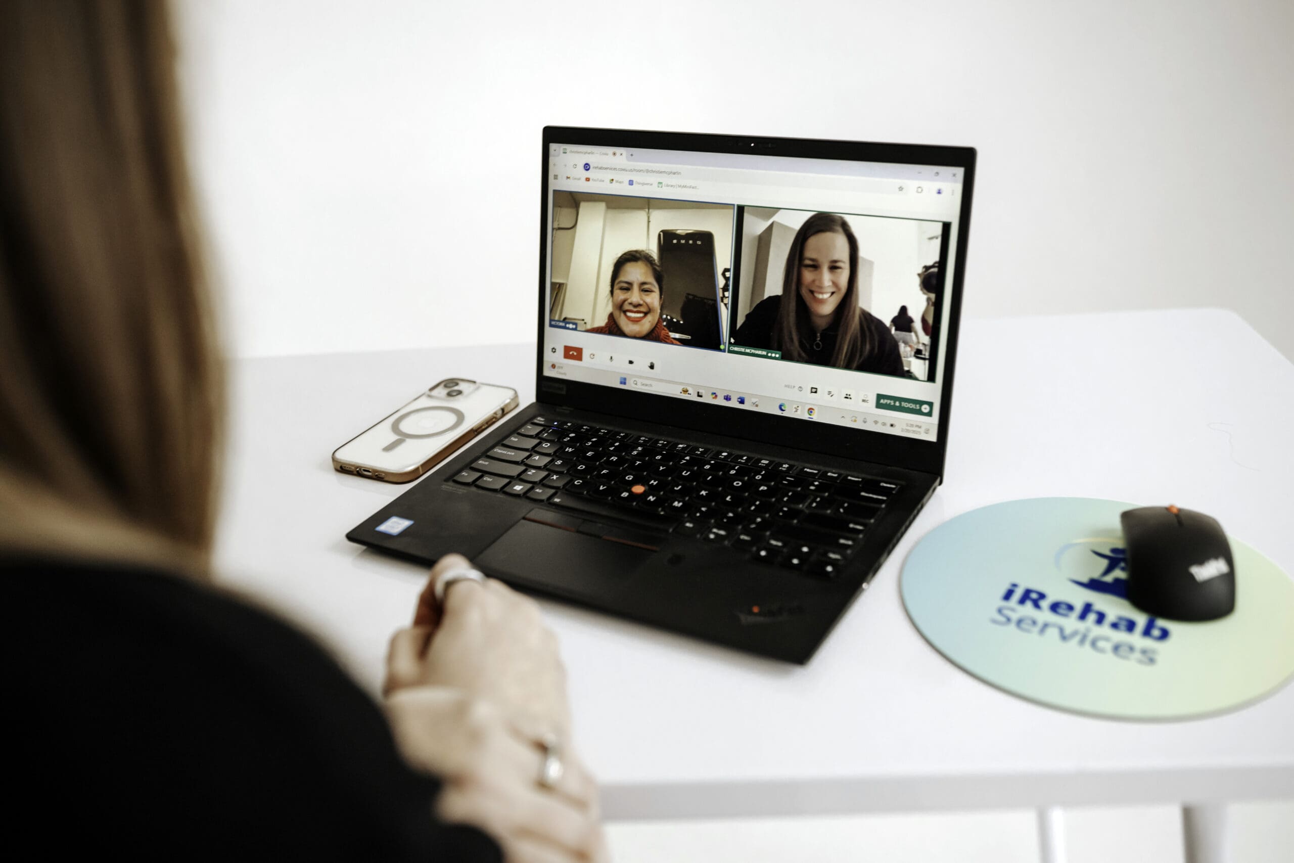 This photo shows two women using a telehealth platform on a laptop